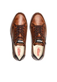 Sneaker in pelle marrone con lacci e zip. Punta rotonda, superficie texturizzata e suole interne imbottite. Logo visibile sulla linguetta.