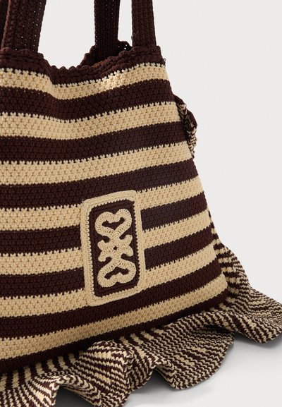 Καφέ και μπεζ τσάντα θαλάσσης πλεκτή με οριζόντιες ρίγες, με ορθογώνιο έμπλαστρο με συμμετρικό κεντητό σχέδιο και βολάν στο κάτω μέρος.