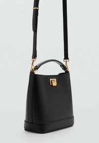 Black leather handbag with a structured shape, gold-tone hardware, and a top handle. Features an adjustable shoulder strap and a clasp closure.