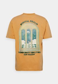 Krátký rukáv, hořčicově žluté tričko s grafickým designem oblouků, na kterém je hvězdná scéna a text "DIGITÁLNÍ ŘÍŠE" a "DOČASNÉ REALITY."