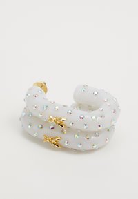 Clip per capelli in resina trasparente a forma di nastro attorcigliato, decorato con strass multicolori e dettagli dorati che ricordano delle foglie.
