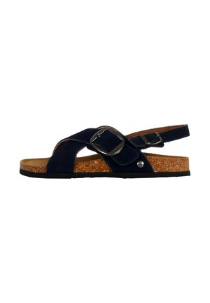 Sandales en daim bleu marine avec une semelle en liège, des sangles croisées et un accent en boucle argentée. Semelle en caoutchouc noir pour traction et confort.