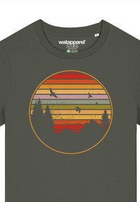 Olivgrünes T-Shirt mit einem kreisförmigen Grafikdesign aus geschichteten Sonnenuntergangsstreifen in Orange, Gelb und Rosa, mit Silhouetten von Bäumen und Vögeln.