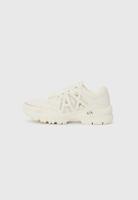 White athletic shoes with mesh and synthetic leather upper, featuring a logo accent, textured side panels, and a chunky sole design.