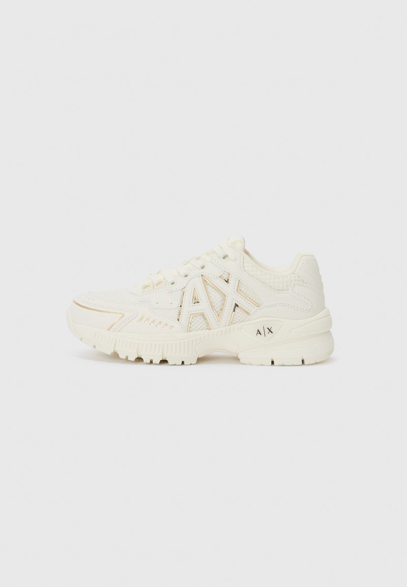 White athletic shoes with mesh and synthetic leather upper, featuring a logo accent, textured side panels, and a chunky sole design.