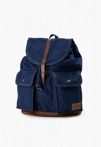 Sinise teksariidest seljakott ümarate klapi, pruunide nahast detailide, kahe eesmist tasku ja nöörkinnisega. Tugev kangas ja detailne õmblus.