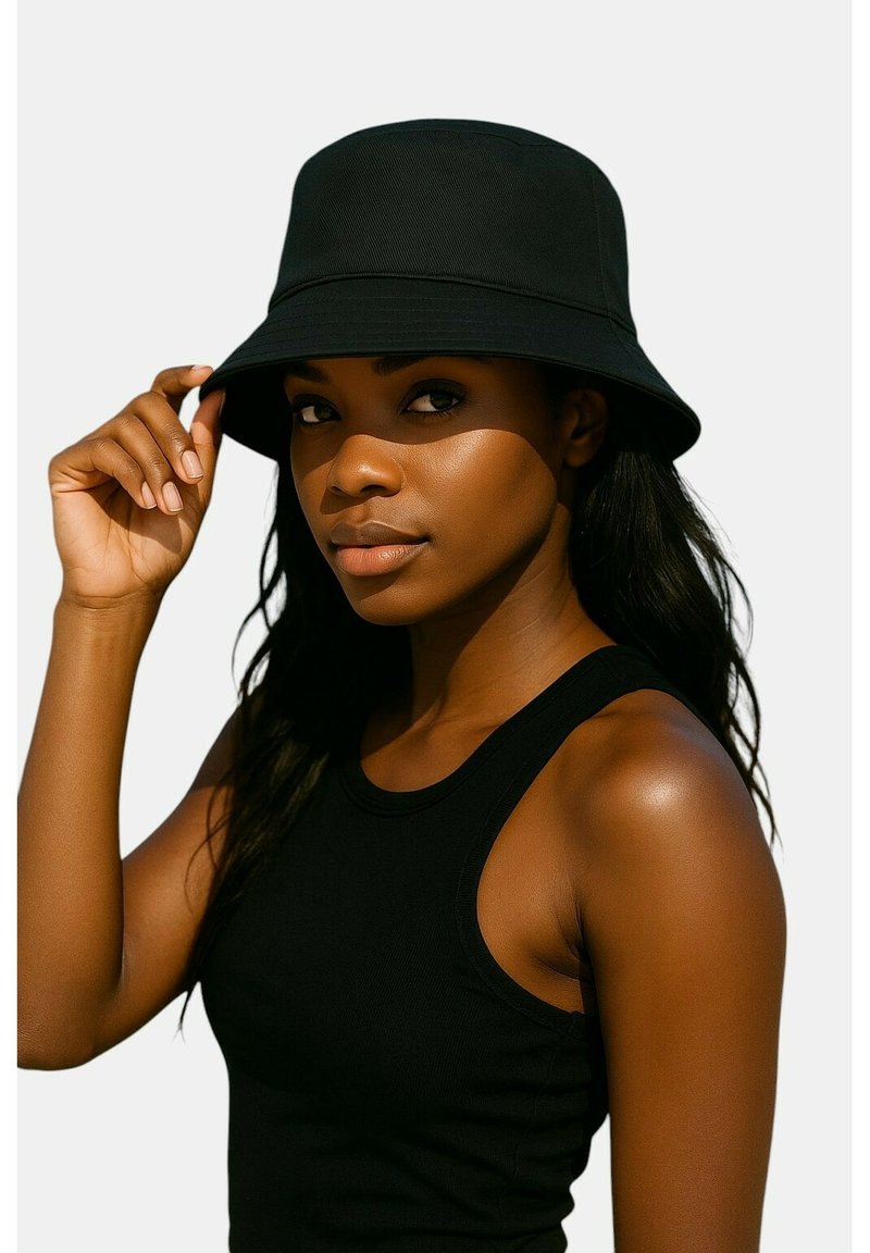 Cappello a secchiello nero con tesa larga, realizzato in tessuto liscio. Il modello indossa una canottiera nera, che mostra una vestibilità rilassata e una scollatura curva.