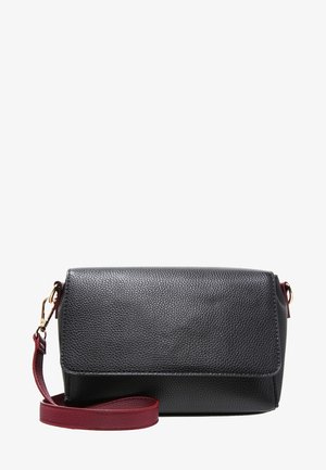 Sac bandoulière en cuir noir grainé avec rabat pliant, sangle bordeaux et détails en métal doré. Forme rectangulaire compacte.