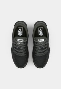 Zwarte Vans sneakers met een gestructureerde bovenkant, voorzien van geperforeerde details en stippenveters. Logo op de tong en een platte zool.