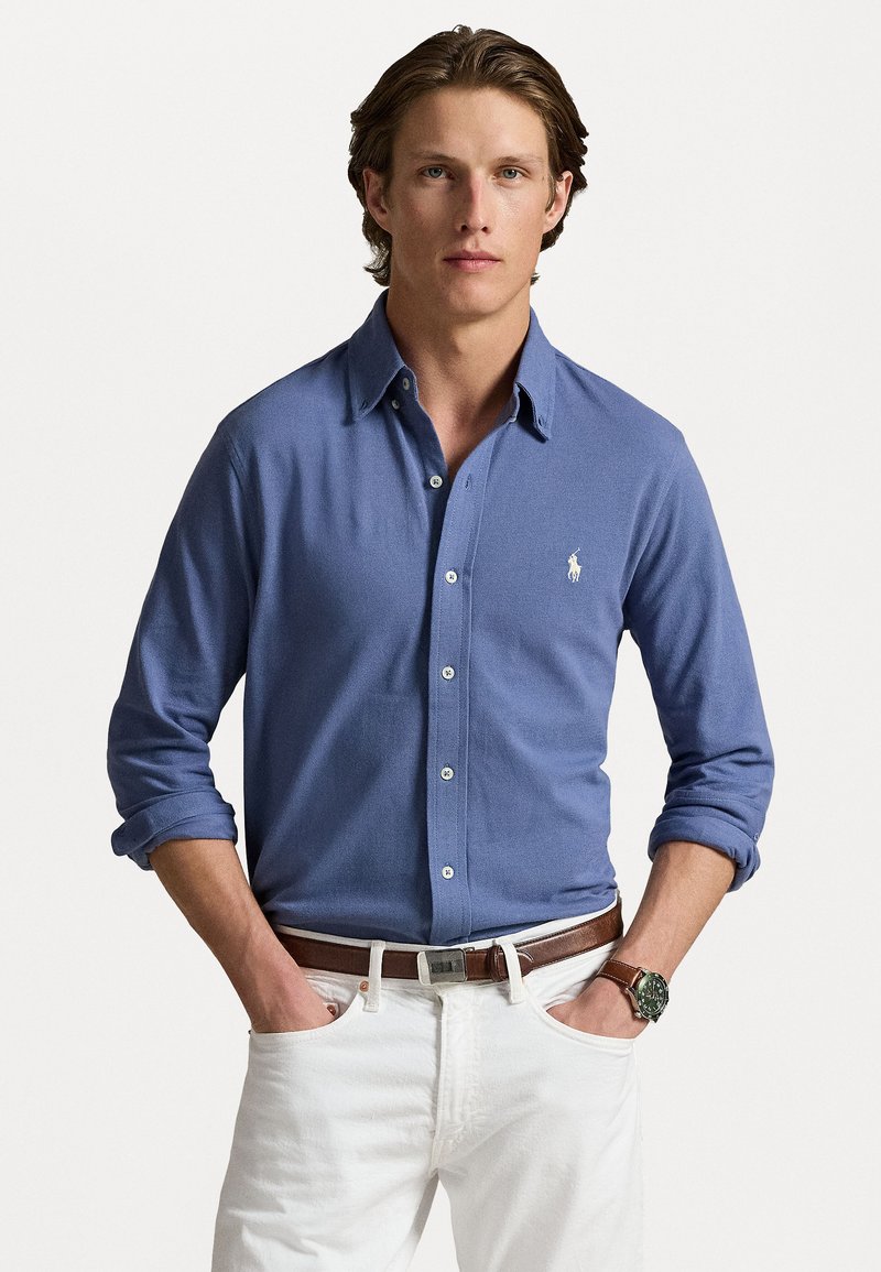 Camicia button-up azzurro chiaro realizzata in cotone, con colletto classico, maniche lunghe con risvolto e un piccolo logo ricamato.