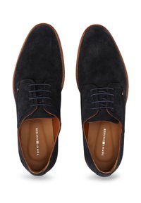 Zwarte suède oxford schoenen met een gladde textuur, ronde neus en tonale veters; bruine binnenvoering en subtiele logodetail aan de binnenzijde.