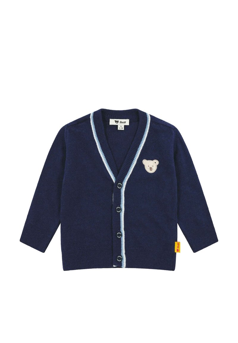 Marineblauwe cardigan van gebreide stof, met een lichtblauwe bies, knopen aan de voorkant en een berenmotief op de borst. Gele label bevestigd.