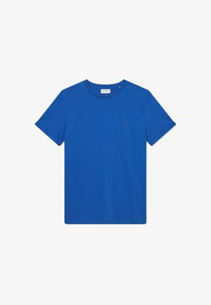 Camiseta de algodón azul con mangas cortas y cuello redondo. Presenta un pequeño logotipo dorado "II" en el lado izquierdo del pecho. Textura suave.