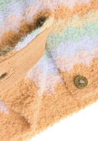 Tissu texturé avec un motif à nervures pastel dans des couleurs orange, menthe, lavande et pêche. Présente une sangle en tissu beige et un bouton en bronze.