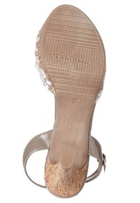 Beige korkkipohjalla varustettu korkokenkä, kukkakuosisella yläosalla ja teksturoidulla kumipohjalla, jossa on brändin nimi ja kenkäkoko.