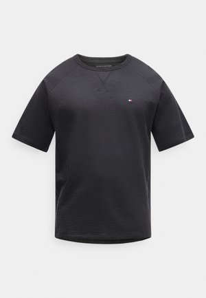 Zwart T-shirt met korte mouwen en ronde hals, met een klein rood-wit-blauw Tommy Hilfiger-logo op de linkerborst tegen een witte achtergrond.