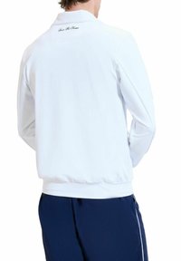 Witte lichtgewicht jas met een kraag en elastische manchetten, voorzien van een subtiel merkteken op de achterste halslijn. Smooth textuur.