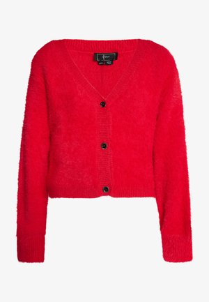 Crvena, skraćena kardigan jakna s pahuljastom teksturom, V-izrezom i rebrastim manžetama. Sadrži pet crnih dugmadi i mekan, topao izgled.