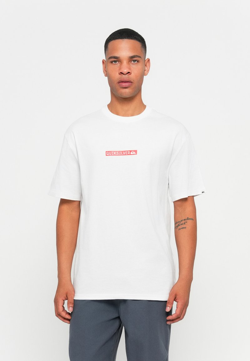 White cotton t-shirt featuring a rectangular red "QUIKSILVER" logo on the chest, short sleeves, and a relaxed fit.
