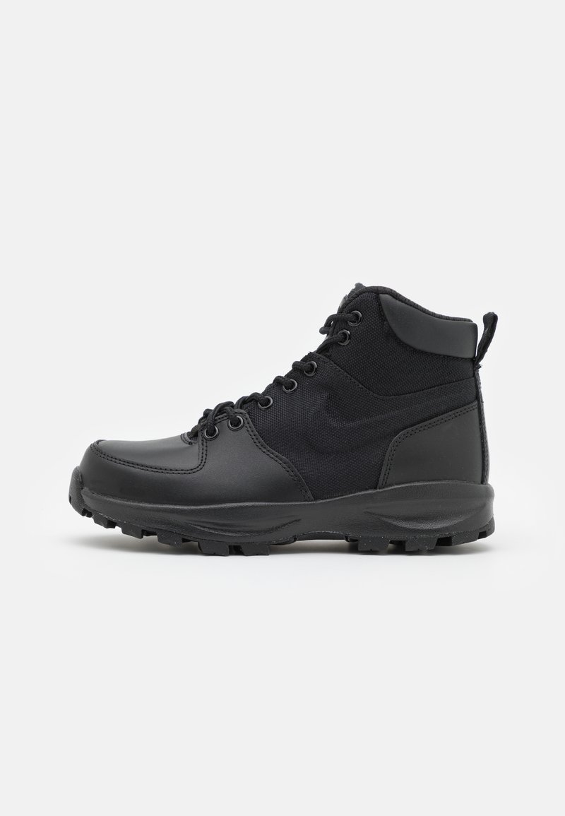 Svart mid-top støvler med en kombinasjon av glatt lær og strukturert stoff, med metalløyelets, en robust såle og en bakre pull-tab.