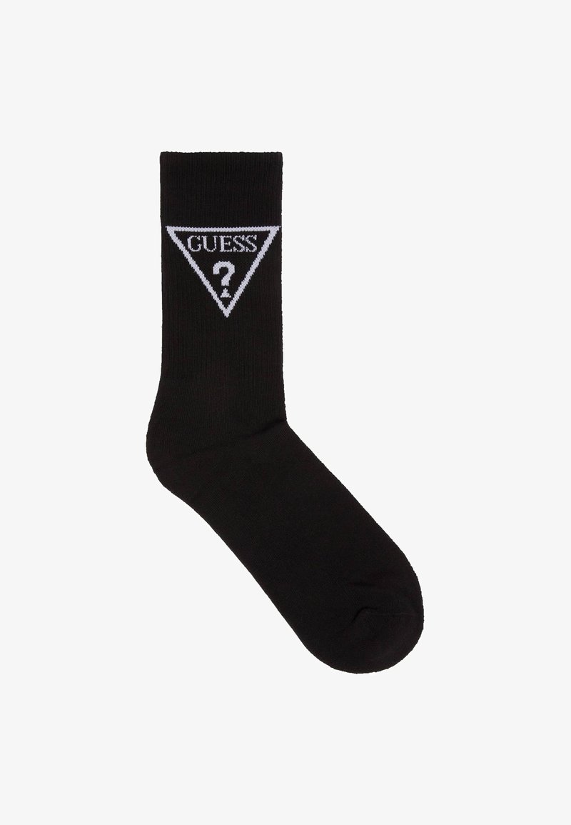 Chaussette noire à texture côtelée, arborant un logo triangulaire blanc avec "GUESS" et un point d'interrogation à l'intérieur. Design classique, style à la cheville.