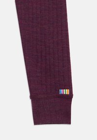 Manica di maglione bordeaux a coste con lavorazione a maglia testurizzata. Presenta un'etichetta a blocchi di colore con multiple strisce al polsino.