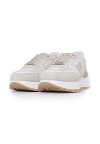 Beżowe sneakersy z cholewką z zamszu i siateczki, białymi akcentami, złotymi detalami oraz grubą białą podeszwą pośrednią z teksturowaną beżową podeszwą zewnętrzną.