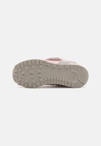 Chaussure rose avec une semelle en caoutchouc gris texturé. Caractéristiques : partie supérieure rembourrée, couture robuste et bande Velcro. Motif de traction sur la semelle.