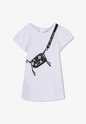 T-shirt blanc à manches courtes bouffantes avec un graphisme noir représentant un sac bandoulière orné de motifs floraux et d'une sangle portant l'inscription « MARC JACOBS ».