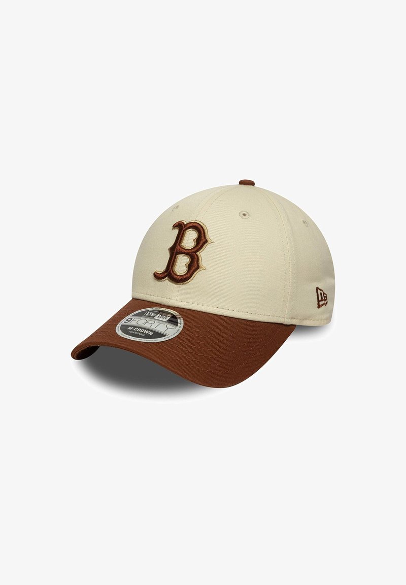 Gorra de béisbol beige con visera marrón. Presenta una letra "B" bordada en relieve en la parte delantera y un pequeño logotipo en el lado.
