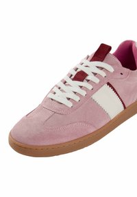 Sneaker in suede rosa con accenti bianchi e borgogna, suola in gomma e lacci bianchi. Design classico con punta arrotondata e finitura testurizzata.