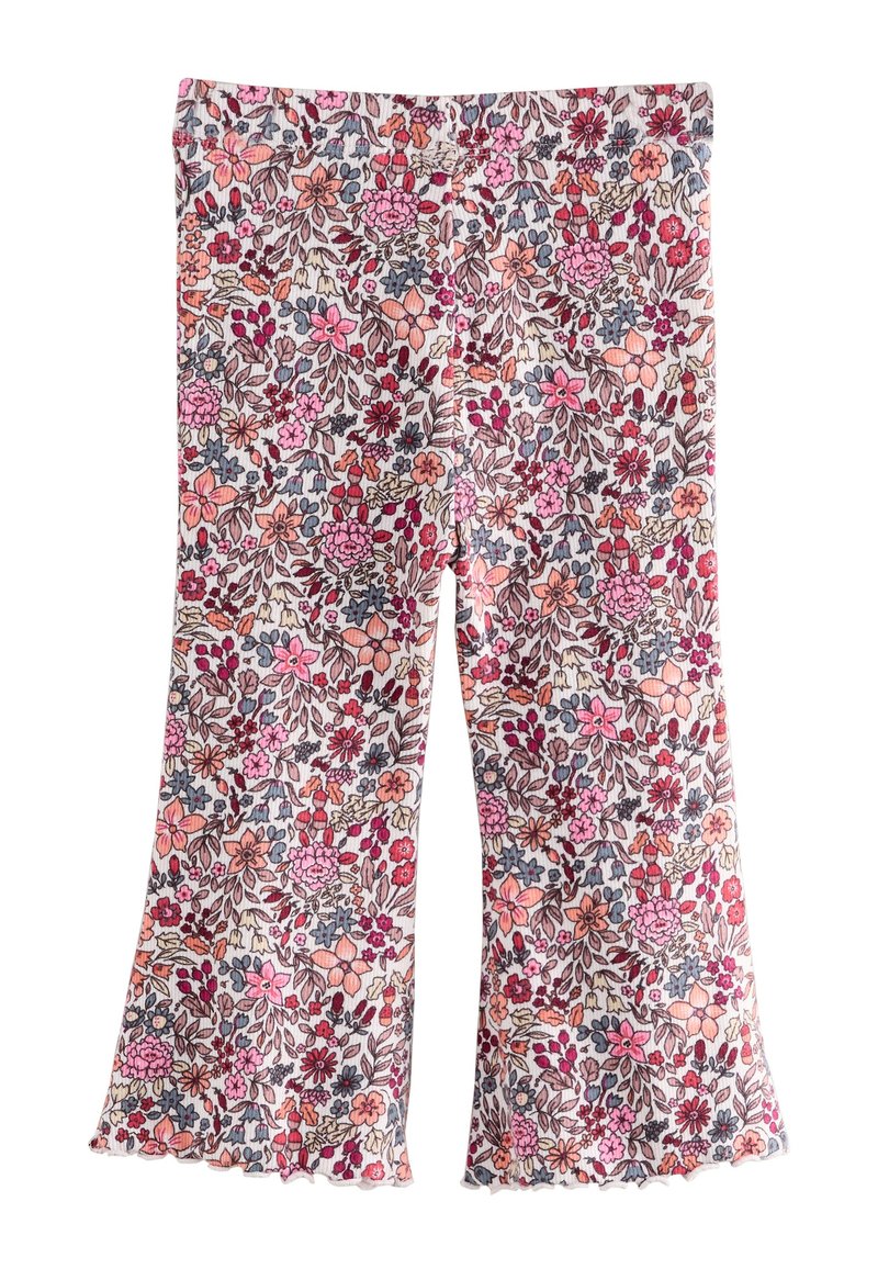 Blommönstrade bell-bottom-byxor med vit bakgrund, prydda med rosa, röda och blå blommor. Mjukt tyg med volangkant.