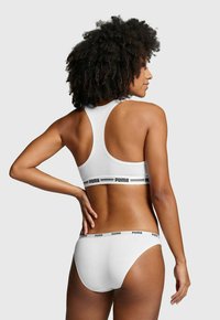 Weißes Sport-BH- und Unterwäscheset aus weichem Baumwollmaterial mit Racerback-Design. Mit schwarzem "PUMA"-Logo am Bund.