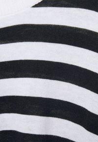 Tissu tricoté rayé noir et blanc avec des rayures de largeurs variées ; texture douce, légèrement extensible, avec un col côtelé.