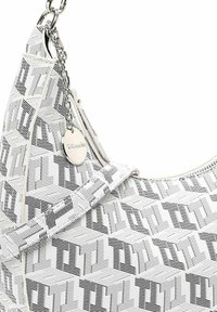 Borsa a tracolla bianca e nera con un design geometrico, dotata di un accento in metallo argentato e di un'etichetta decorativa, realizzata in materiale testurizzato.