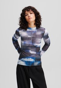 Langdurige mouwtop in een gemengde abstracte patroon van blauw, zwart en wit; voorzien van een ronde hals en een aansluitend ontwerp met branding op de borst.