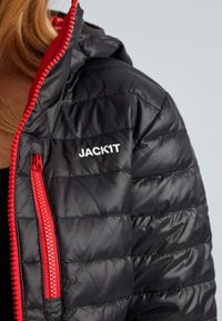 Sort puffjakke med hætte, med en rød lynlås og detaljer. Inkluderer mærkenavnet "JACK1T" i hvidt på fronten.