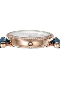 Montre en or rose avec un cadran blanc texturé, une lunette ornée de cristaux et un bracelet en cuir bleu. Dispose d'un boîtier rond et d'une couronne à bouton-poussoir.