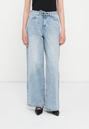 Lys blå vidbenede jeans med høj talje og snoretræk, der har traditionel denimtekstur og frynsede kantdetaljer.