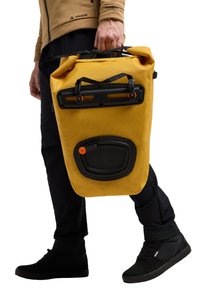 Bolsa impermeable amarilla con una superficie texturada, asa superior, herrajes negros y un acento naranja. Diseñada para la durabilidad y la portabilidad.