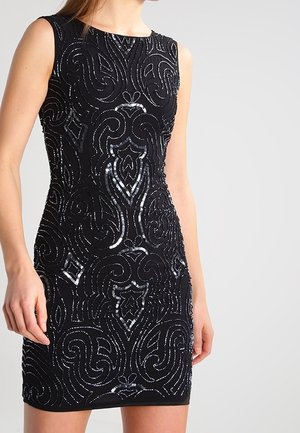 Czarna sukienka bez rękawów o dopasowanym kroju, zdobiona misternymi, wirującymi wzorami z srebrnych cekinów.