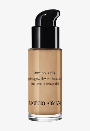 Bottiglia di vetro di fondotinta Luminous Silk, con un tappo a pompa nero, liquido beige e testo nero per i dettagli del prodotto e il nome del marchio.