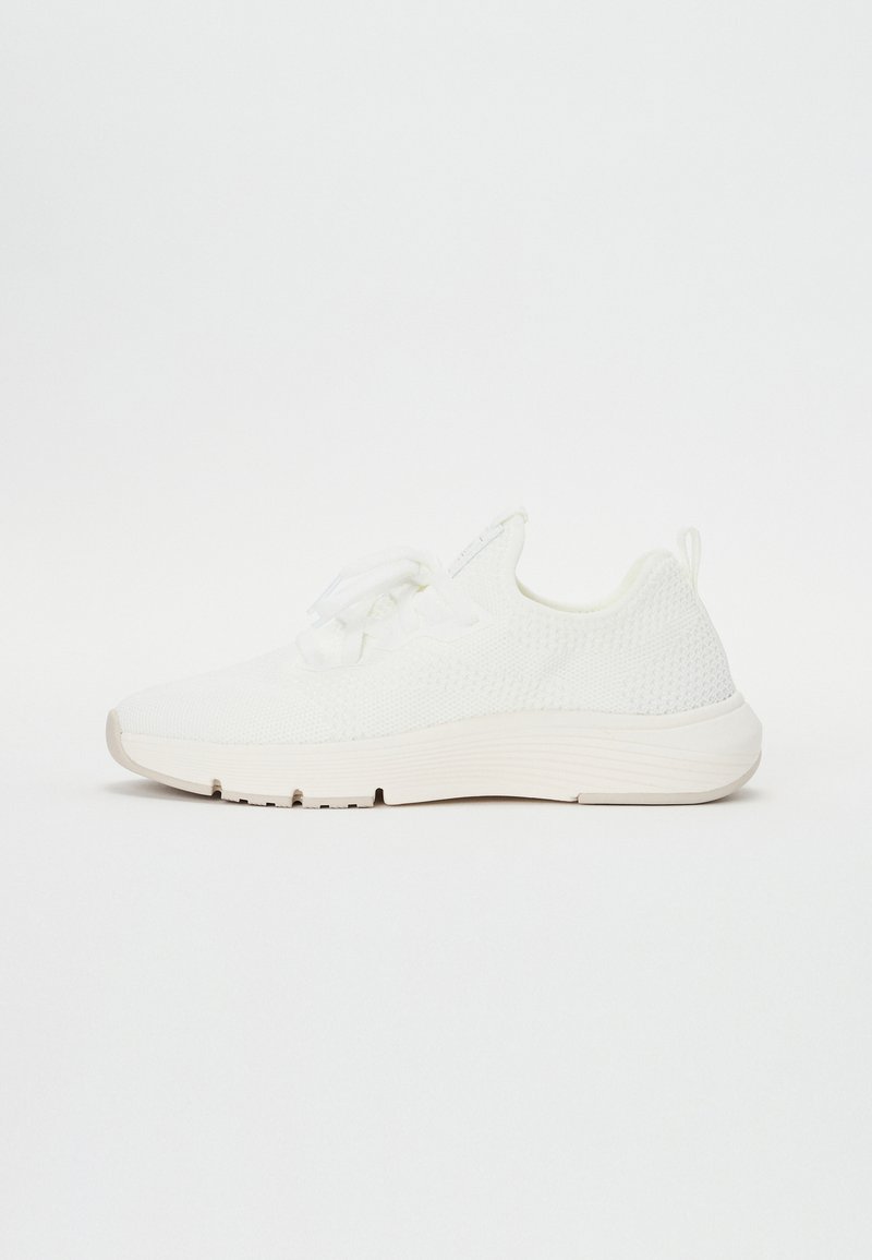 Baskets en tricot blanc avec une tige texturée, bout rond, laçage à l'avant et semelle en caoutchouc effilée. Design minimaliste avec une finition lisse.