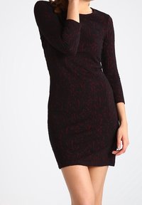 Czarna, długozasłonowa sukienka z głęboką czerwoną, kwiatową wzorą. Dopasowany krój, do kolan, fakturowany materiał, okrągły dekolt.