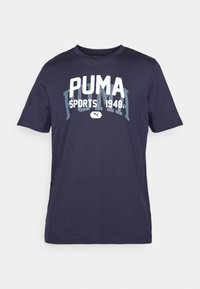 Navy-blauwe katoenen T-shirt met korte mouwen en een ronde hals. Voorzien van een grote witte "PUMA SPORTS 1948" grafiek op de voorkant.