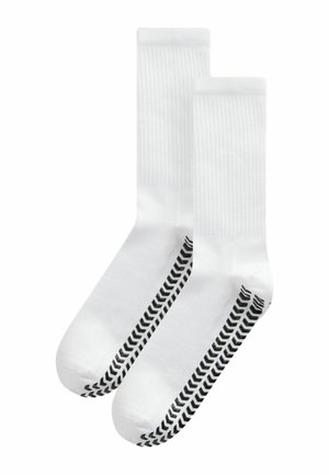 Biele ponožky s ribovanou textúrou a čiernym chevronovým vzorom na bokoch. Dizajn je v kotníkovej dĺžke s posilnenou časťou na prstoch.
