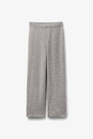 Grijze, wijd uitlopende broek gemaakt van zachte, gestructureerde stof. Voorzien van een elastische tailleband en een eenvoudig, recht model.