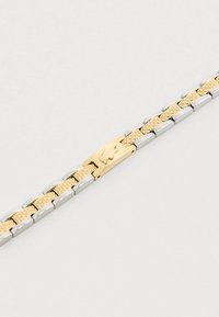 Hõbedast ja kullast metallist käevõru, mille keskel on tekstuuriga kuldne link, poleeritud hõbedased lingid ning kuulalogo aktsendiga kinnitus.