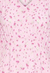 Tissu rose clair avec un petit motif floral rose et blanc, froncé sous un décolleté en V.