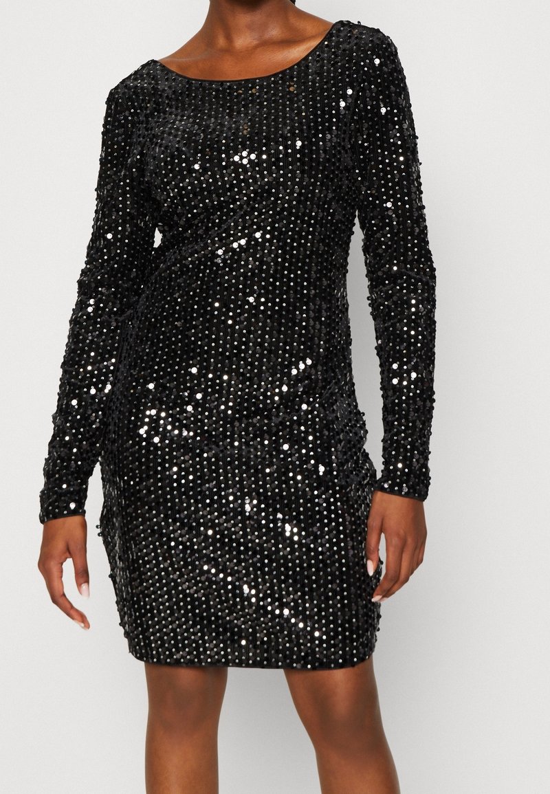 Czarna sukienka z cekinami, z długimi rękawami, dopasowaną sylwetką, okrągłym dekoltem i fakturowaną powierzchnią utworzoną przez gęste, połyskujące cekiny.